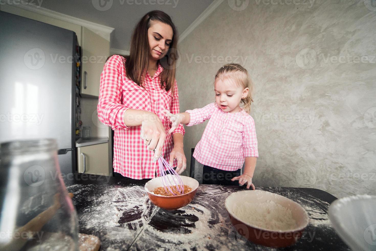 mamá e hija juntas en la cocina foto