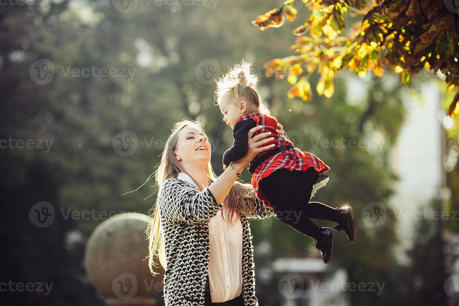 Mother and little daughter playing in a park photo