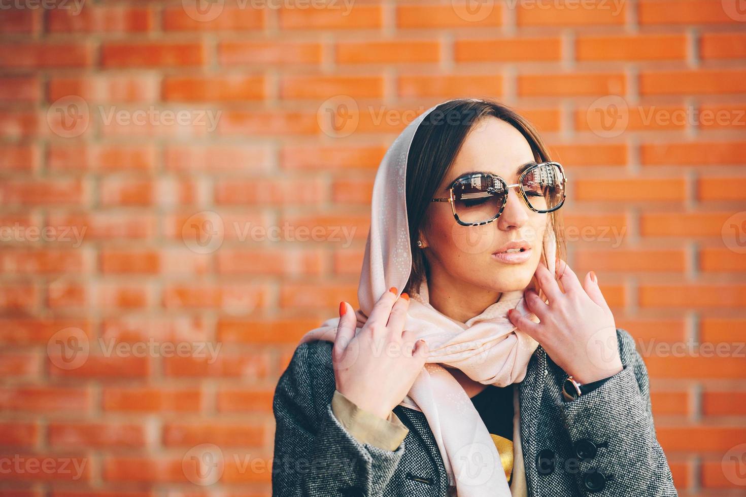 girl posing on a background of red brick wall photo