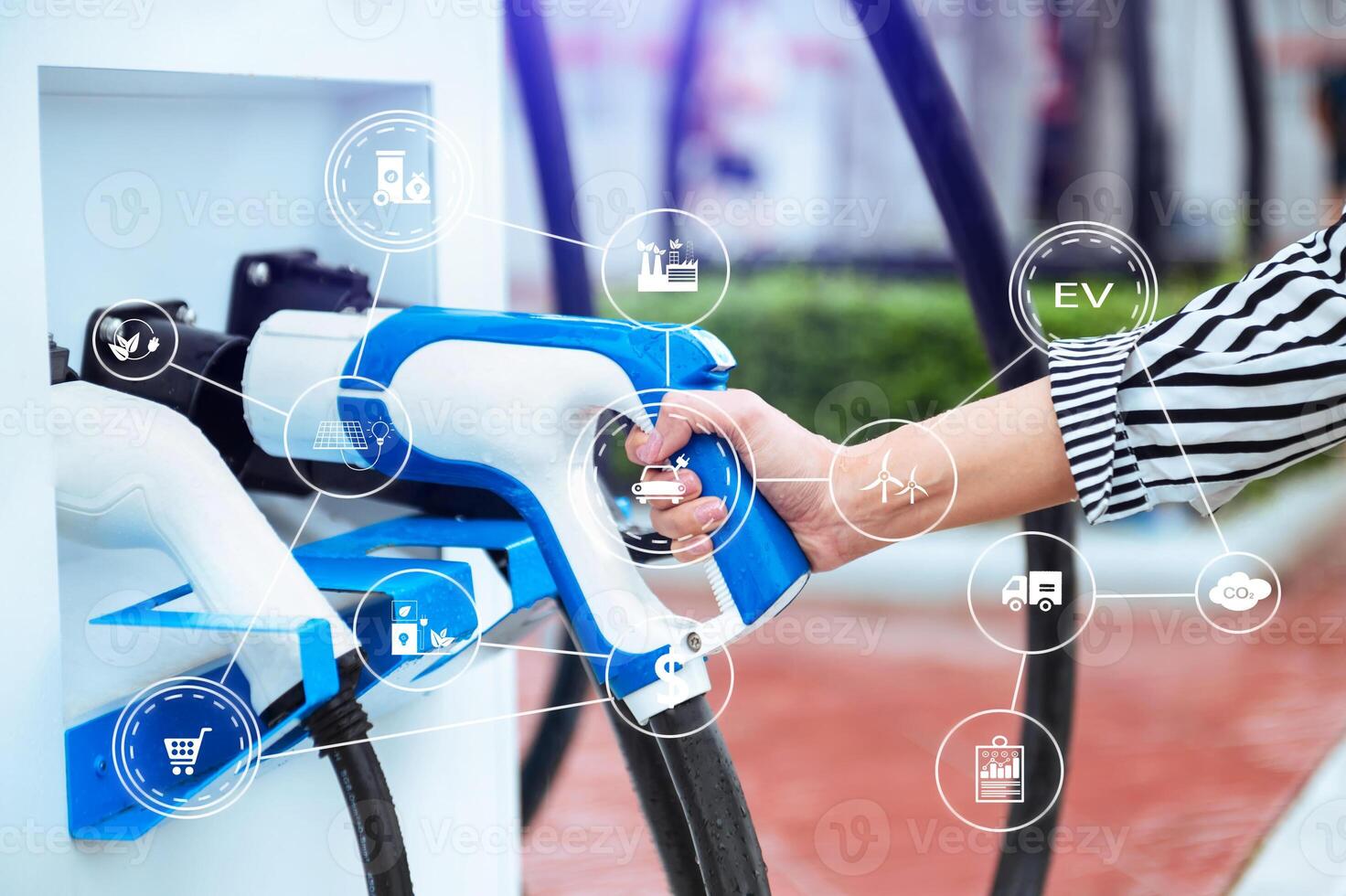 Hand plugging in a charger in an electric car socket.Electric car or ev is charging at station . with VR icon photo
