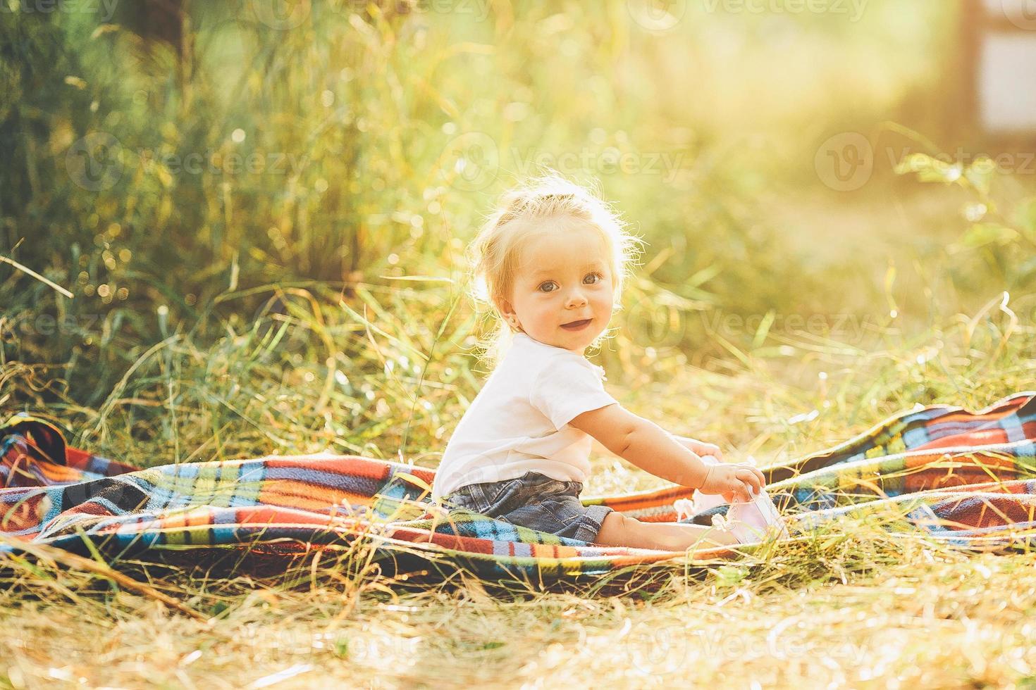 little girl sitting on the lawn photo