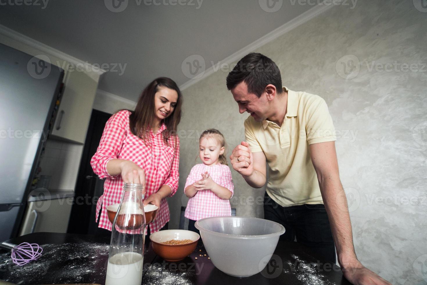 Dad, mom and daughter together in the kitchen photo