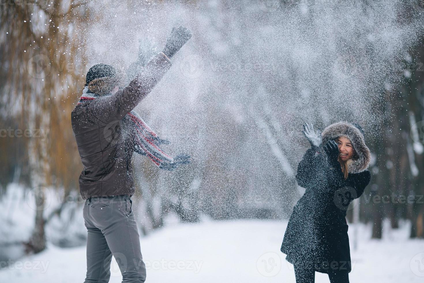 man and woman throwing snowballs photo