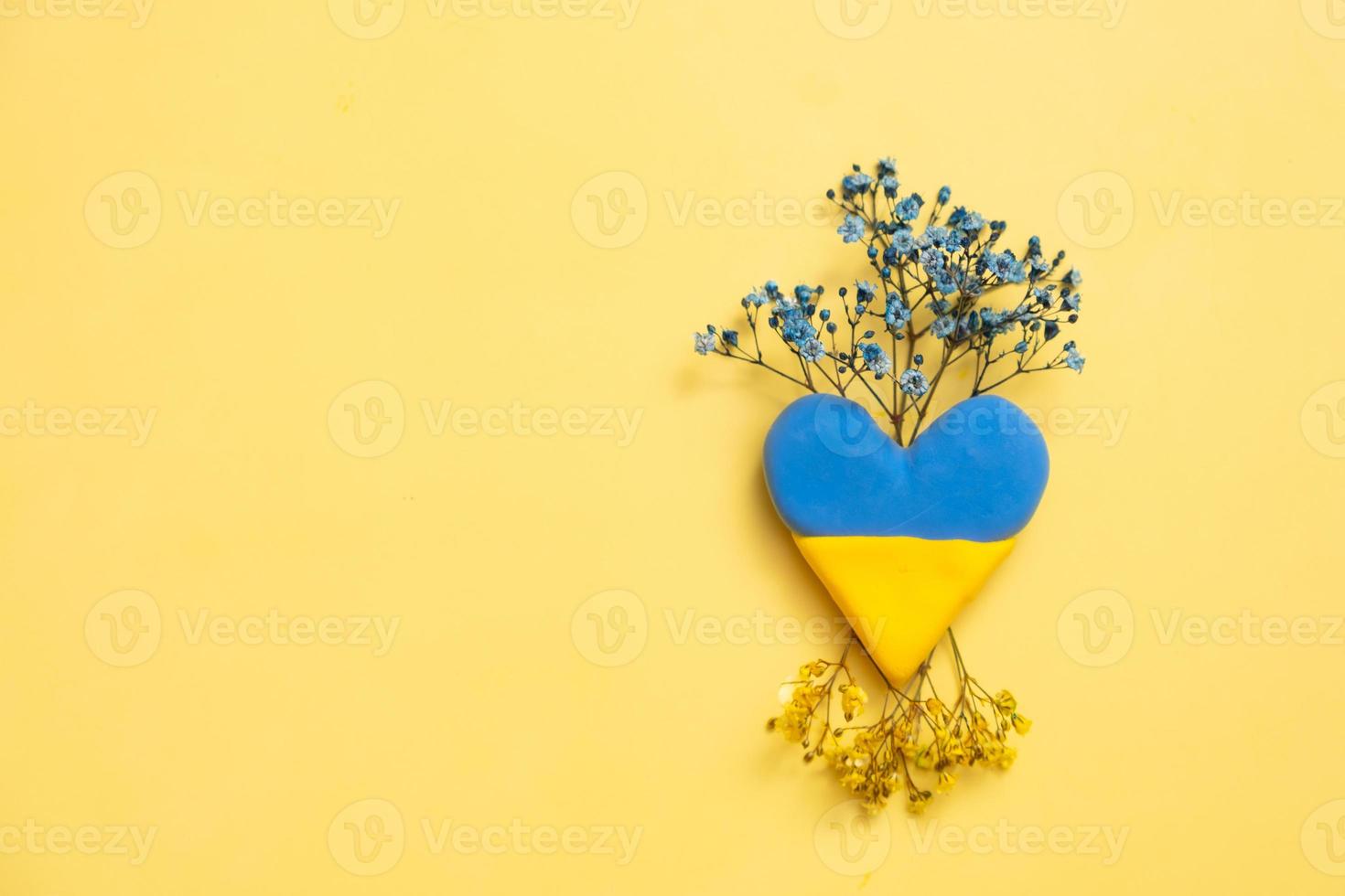 Blue and yellow heart and flowers on yellow background. Treatment and recovery of Ukraine concept photo