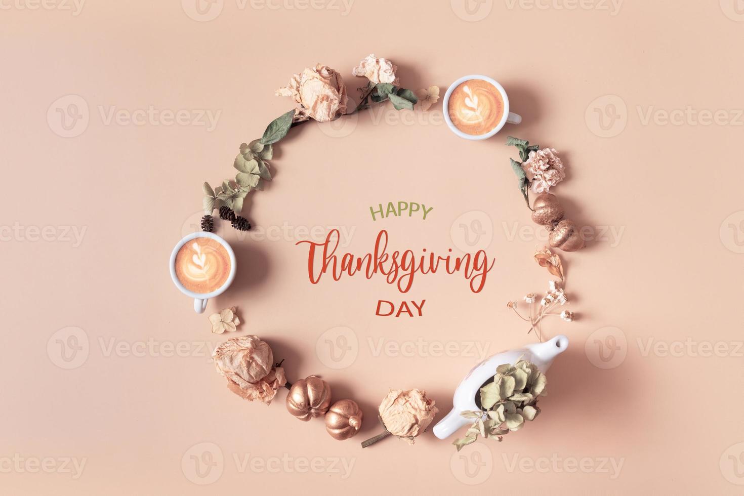 Autumn composition with Happy Thanksgiving Day greeting text. Wreath made of dried leaves and coffee cups on pastel beige background photo