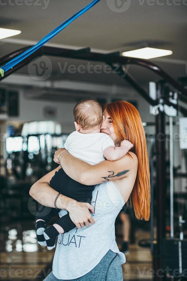 joven madre con su hijo pequeño en el gimnasio foto