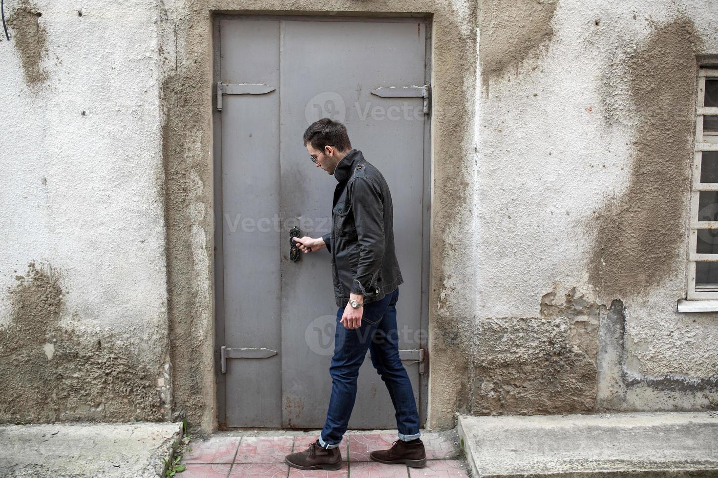 A man dressed in jeans on the background of doors photo