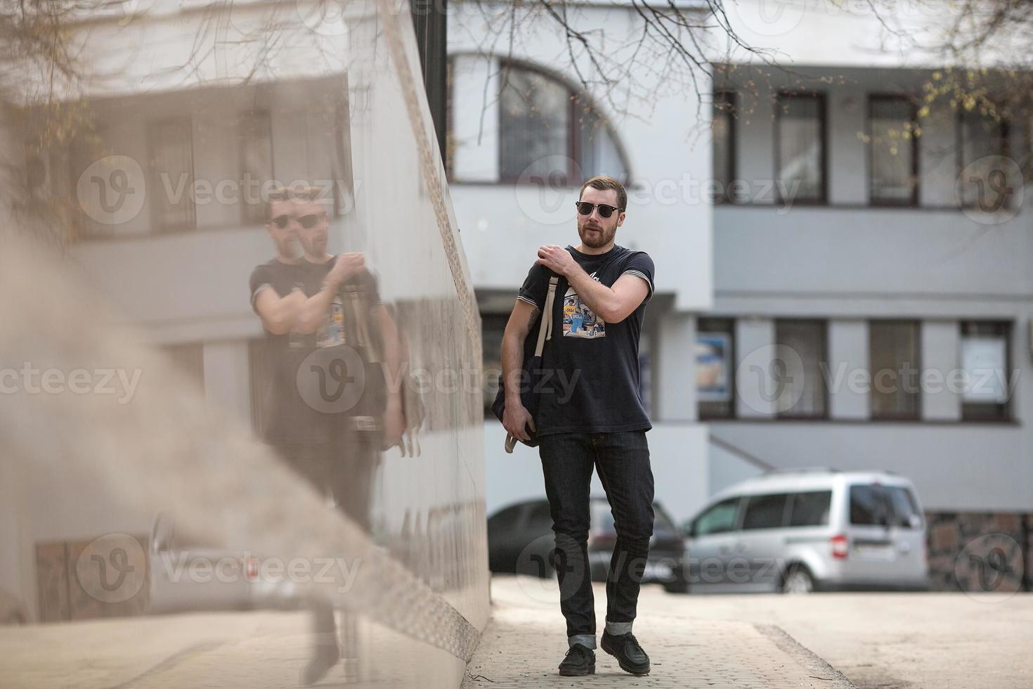 The man in the authentic boots and selvedge jeans  on a background of old city photo