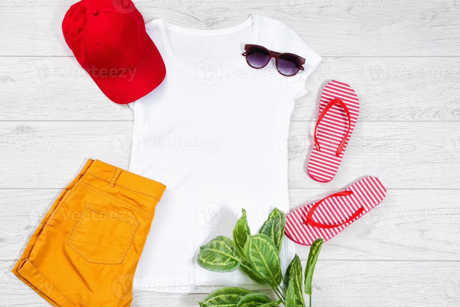 White female t shirt flip flops mock up flat lay on wooden background. Top view and copy space. Mockup t-shirt and summertime. Template blank shirt. Yellow hat photo