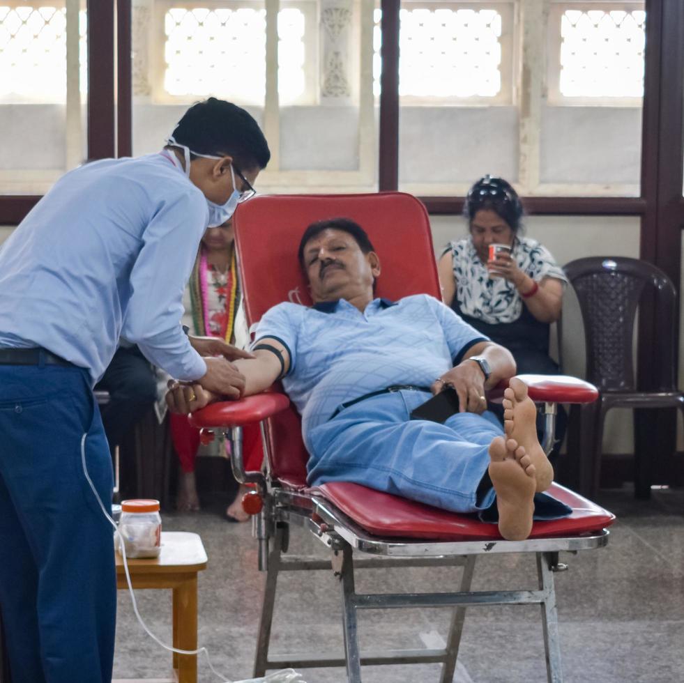 Delhi, India, June 19 2022 - Blood donor at Blood donation camp held at Balaji Temple, Vivek Vihar, Delhi, India, Image for World blood donor day on June 14 every year, Blood Donation Camp at Temple photo