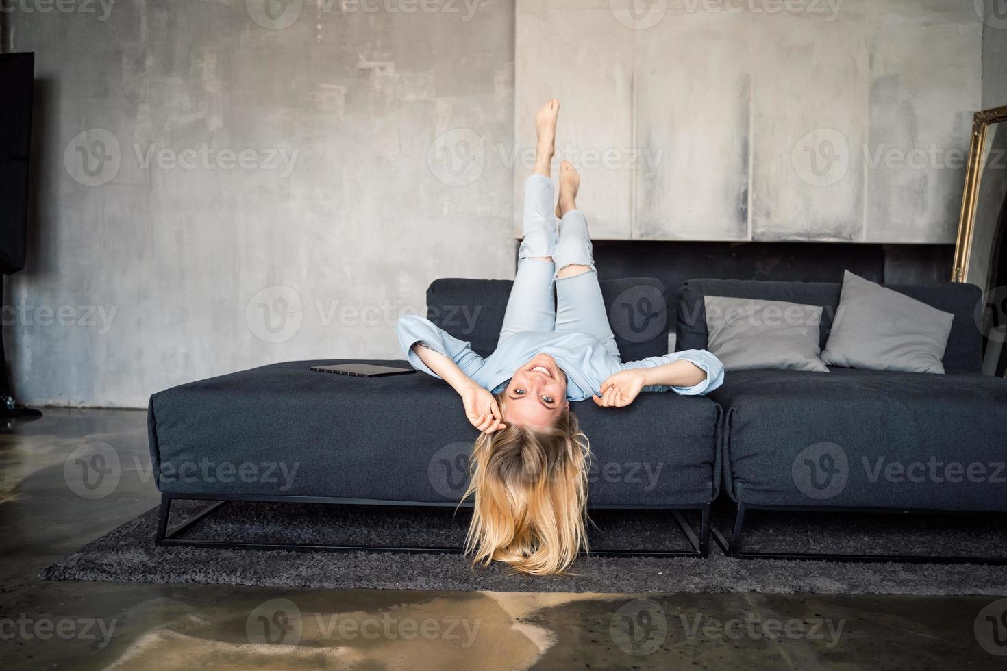 Woman enjoying on a couch with head upside down. photo