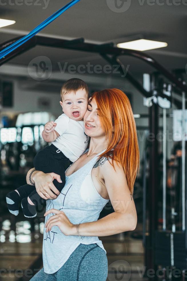 joven madre con su hijo pequeño en el gimnasio foto