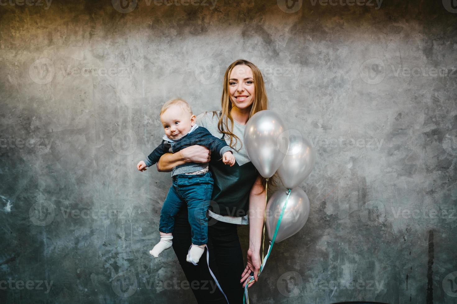 mamá está sosteniendo a su pequeño hijo en sus brazos foto