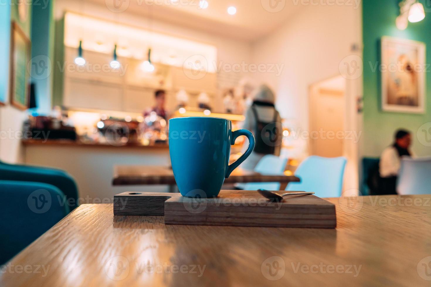 Hot cappuccino coffee in coffee shop on wooden table photo