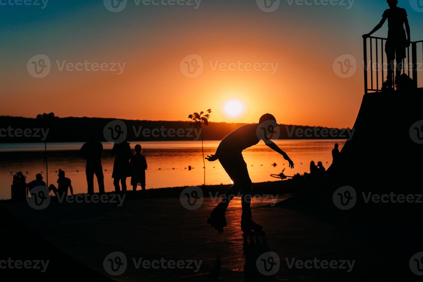 people are resting on a sports field by the river bank photo