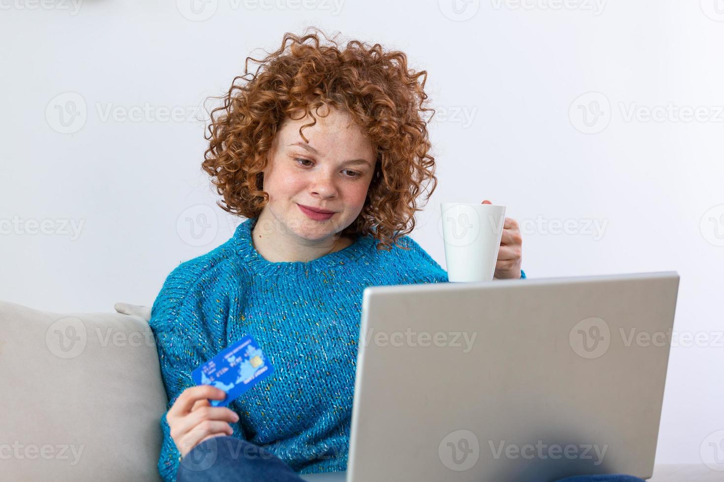 joven hermosa mujer feliz por encontrar artículos de compras para la venta en línea. hermosa chica usando una computadora portátil para comprar en línea en casa y tomar café foto