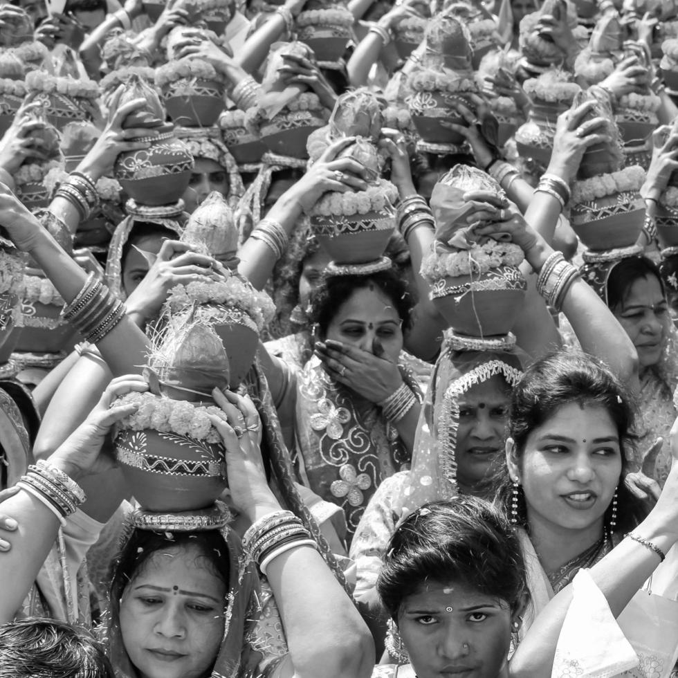 Delhi, India April 03 2022 - Women with Kalash on head during Jagannath Temple Mangal Kalash Yatra, Indian Hindu devotees carry earthen pots containing sacred water with coconut on top-Black and White photo