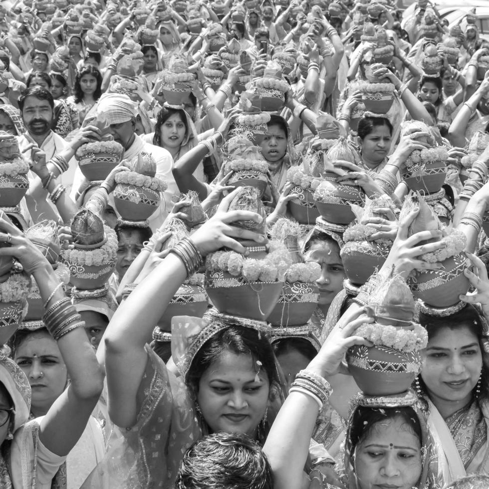 Delhi, India April 03 2022 - Women with Kalash on head during Jagannath Temple Mangal Kalash Yatra, Indian Hindu devotees carry earthen pots containing sacred water with coconut on top-Black and White photo