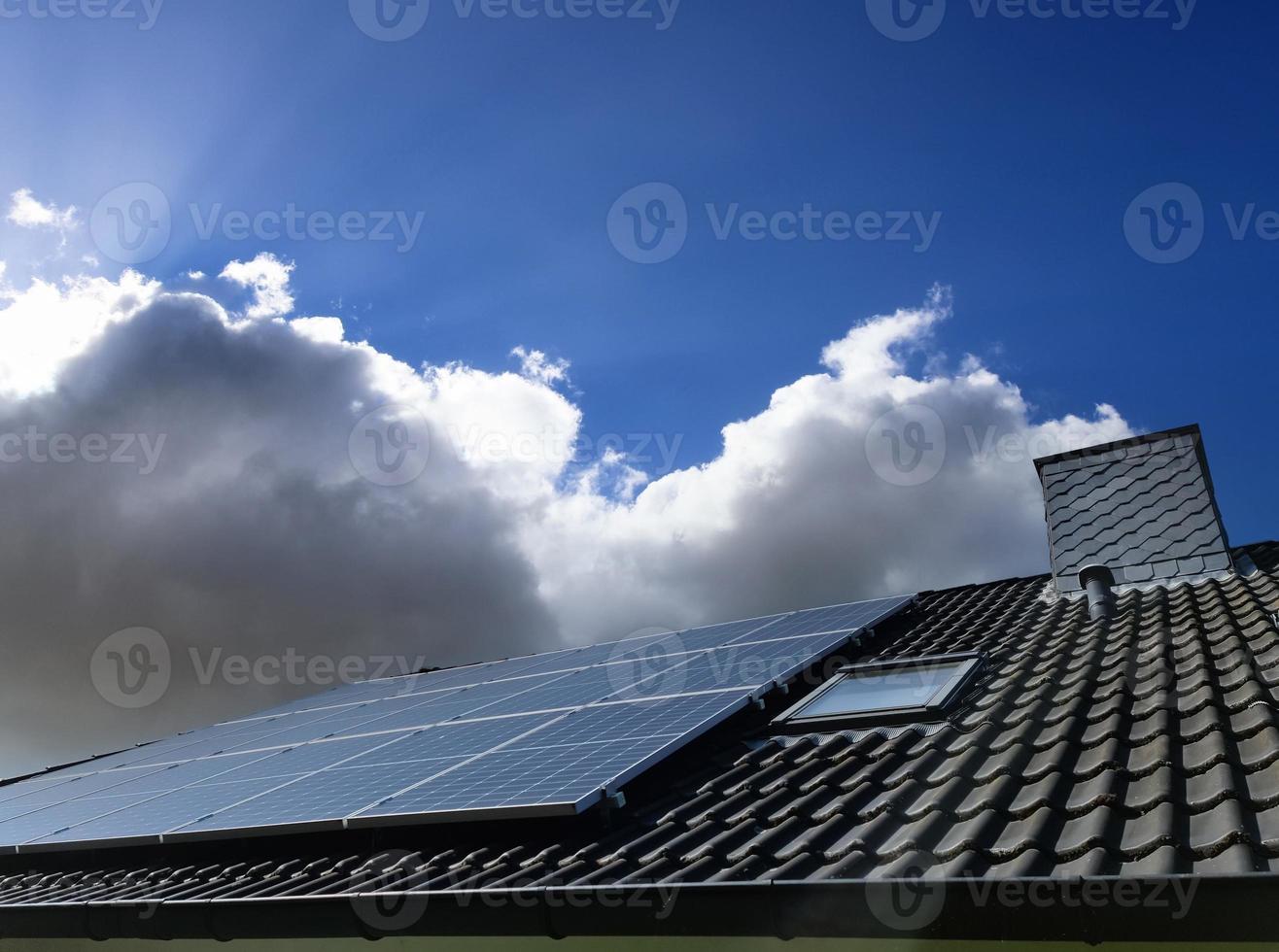 Solar panels producing clean energy on a roof of a residential house photo