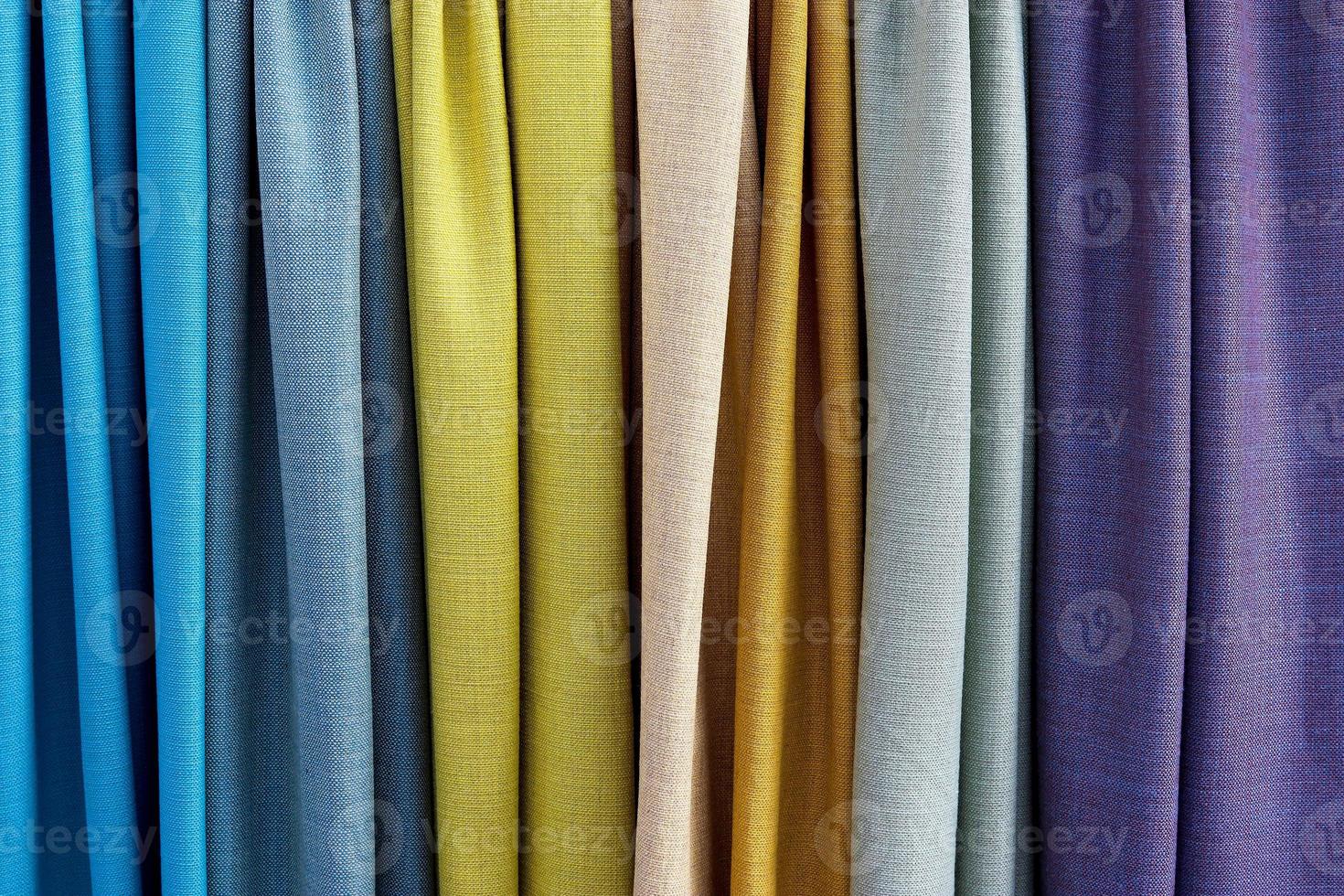 Detailed close up view on samples of cloth and fabrics in different colors found at a fabrics market photo