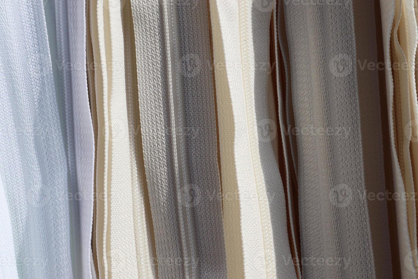 Detailed close up view on samples of cloth and fabrics in different colors found at a fabrics market photo