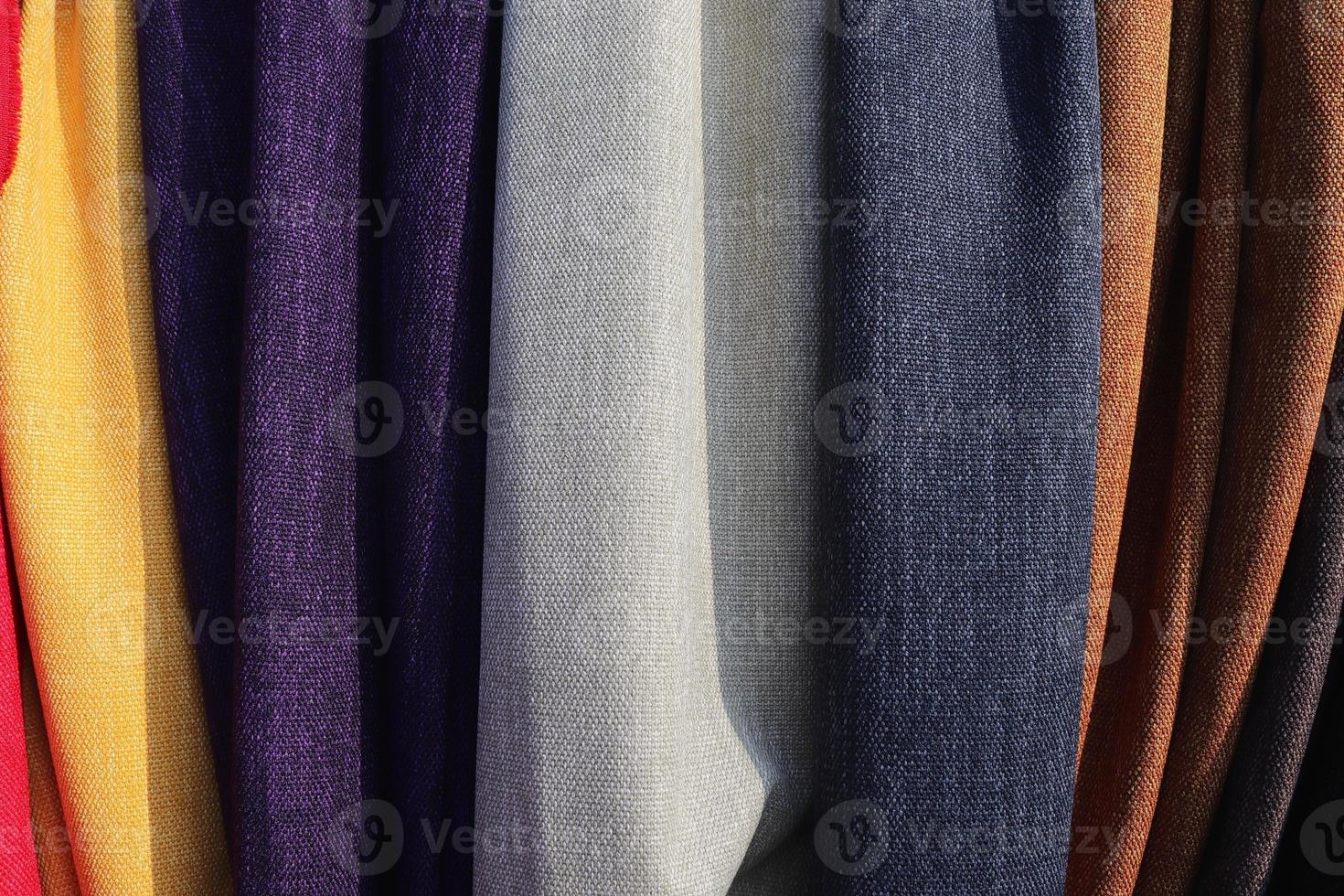Detailed close up view on samples of cloth and fabrics in different colors found at a fabrics market photo
