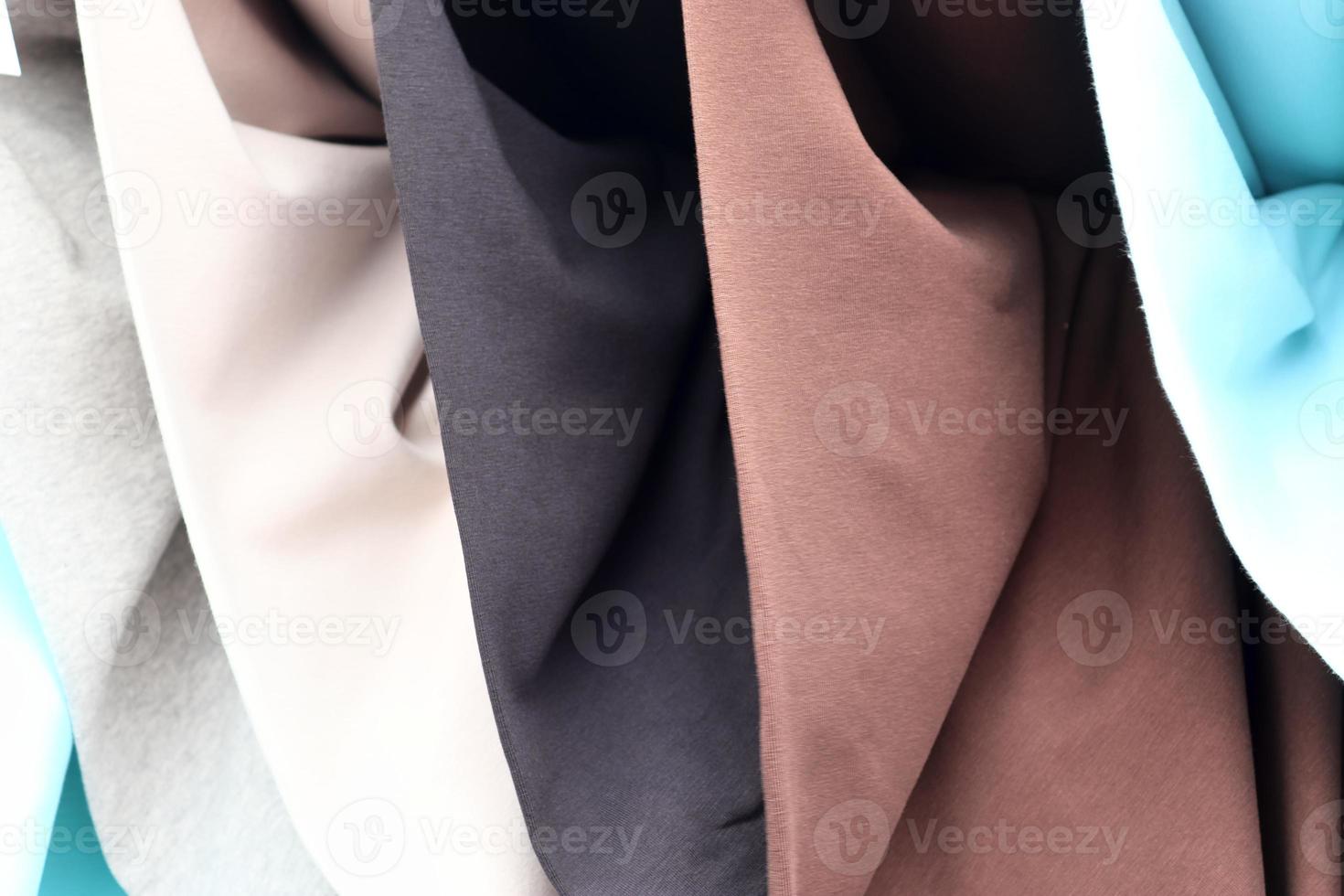 Detailed close up view on samples of cloth and fabrics in different colors found at a fabrics market photo