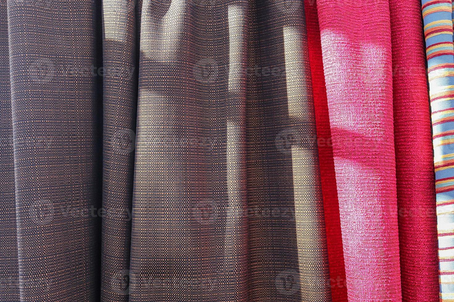 Detailed close up view on samples of cloth and fabrics in different colors found at a fabrics market photo