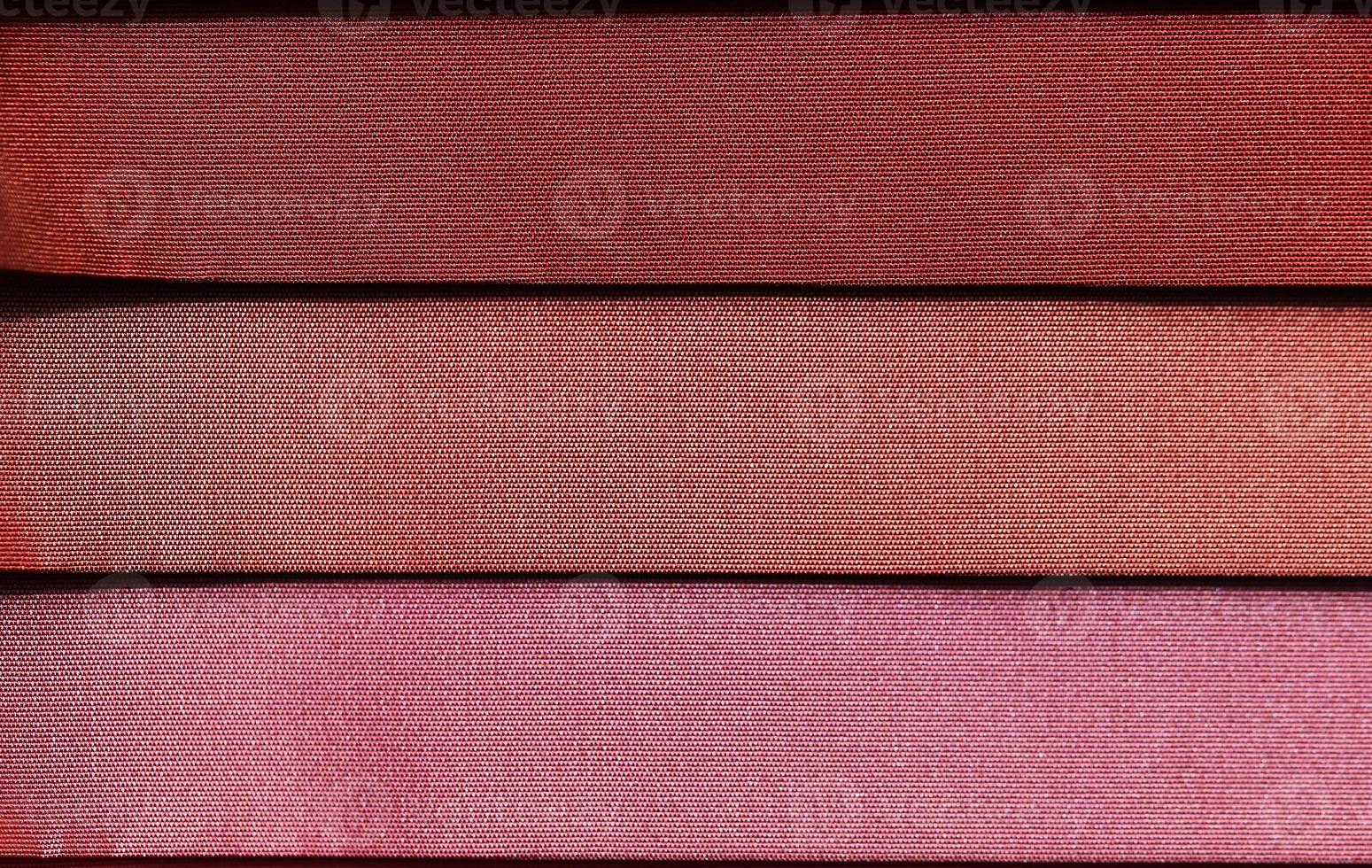 Detailed close up view on samples of cloth and fabrics in different colors found at a fabrics market photo