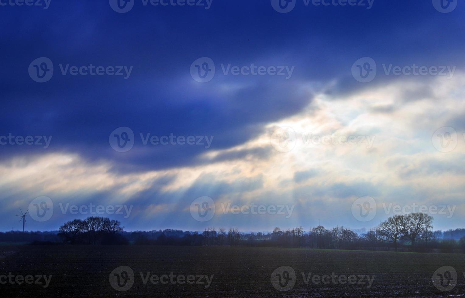 Beautiful view at sunbeams with some lens flares and clouds in a blue sky photo