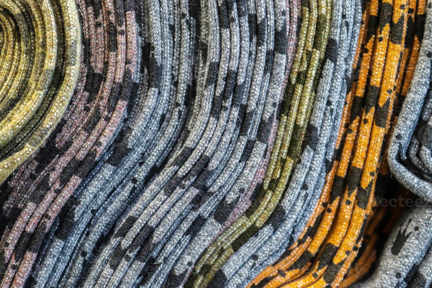 Detailed close up view on samples of cloth and fabrics in different colors found at a fabrics market photo