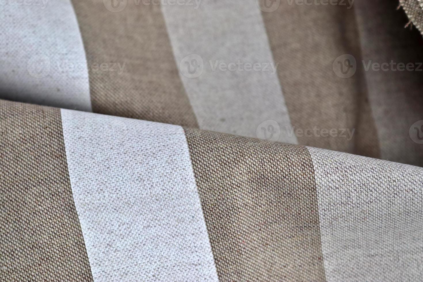 Detailed close up view on samples of cloth and fabrics in different colors found at a fabrics market photo