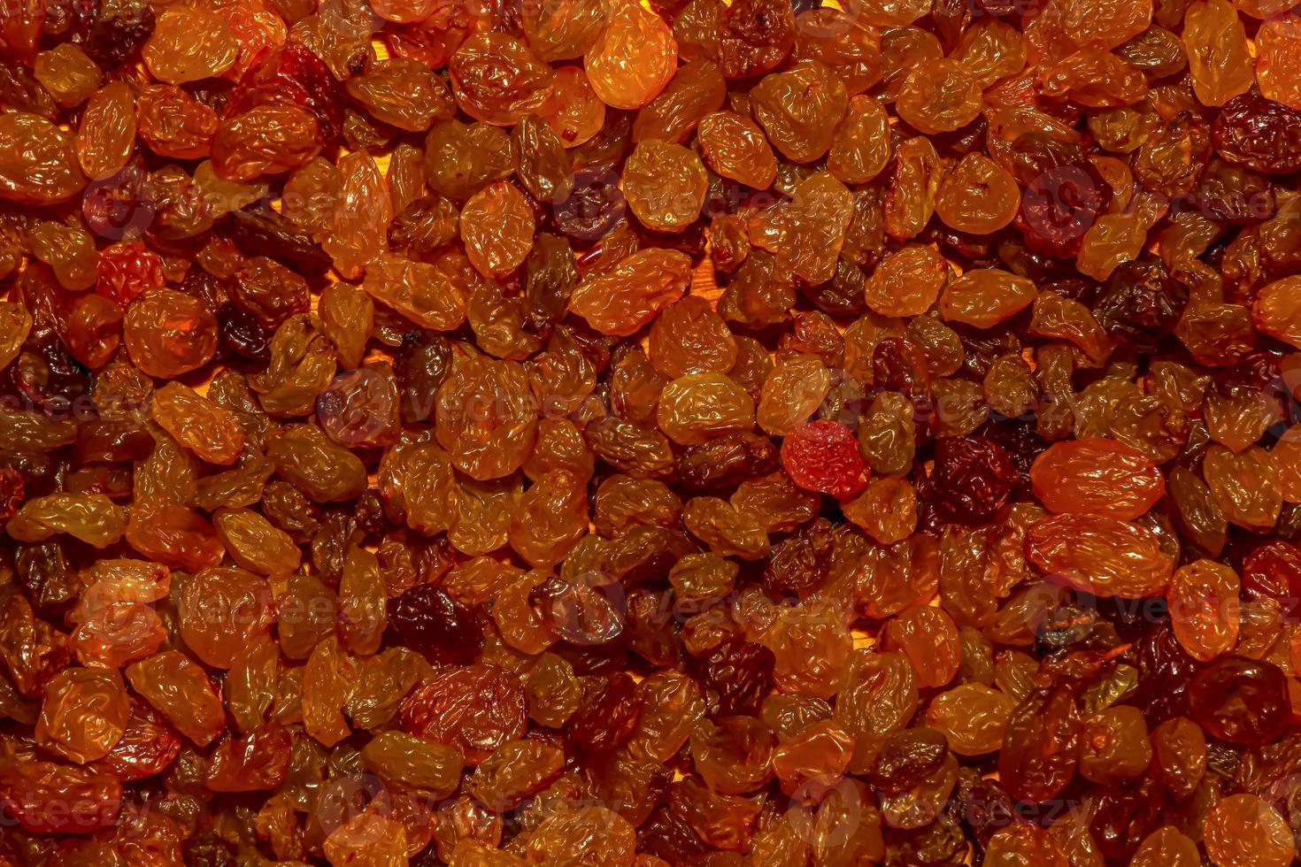 Texture of yellow and orange raisins from pink grapes. Raisins background photo