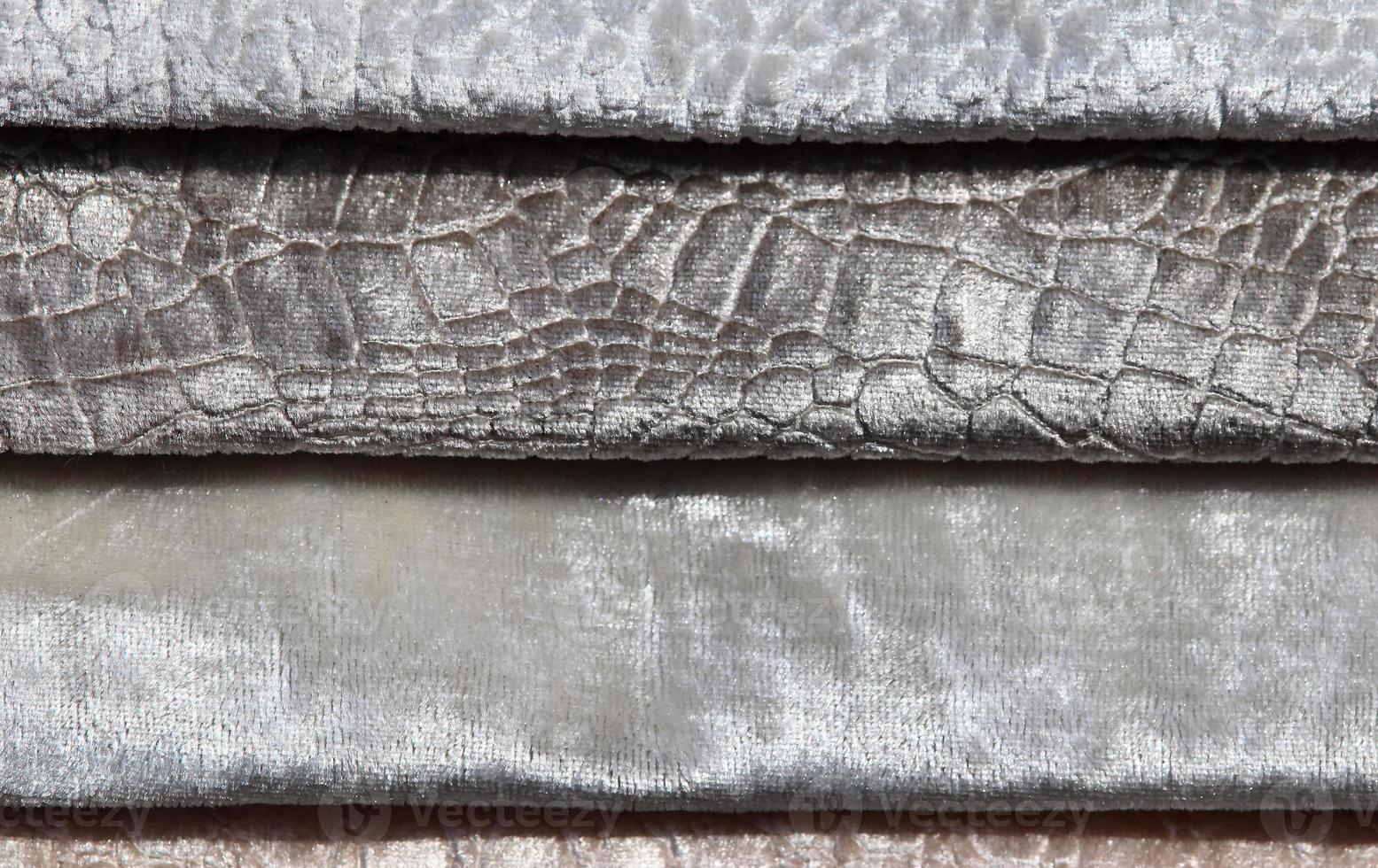 Detailed close up view on samples of cloth and fabrics in different colors found at a fabrics market photo