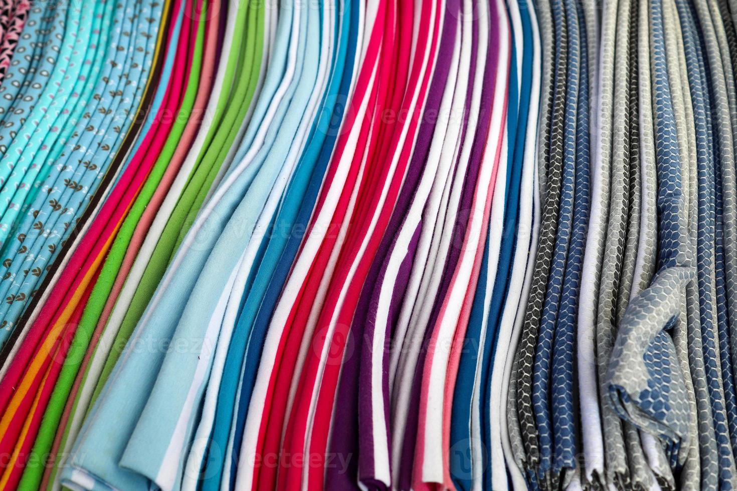 Detailed close up view on samples of cloth and fabrics in different colors found at a fabrics market photo
