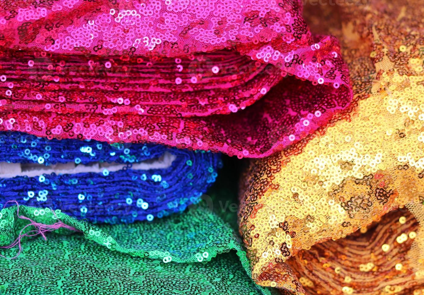 Detailed close up view on samples of cloth and fabrics in different colors found at a fabrics market photo