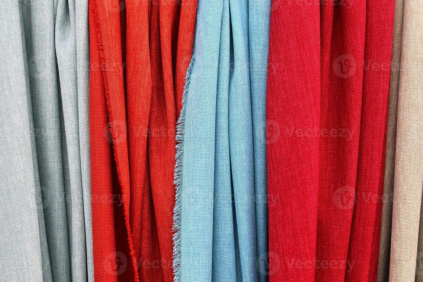 Detailed close up view on samples of cloth and fabrics in different colors found at a fabrics market photo