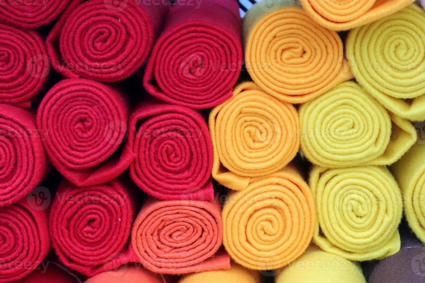 Detailed close up view on samples of cloth and fabrics in different colors found at a fabrics market photo