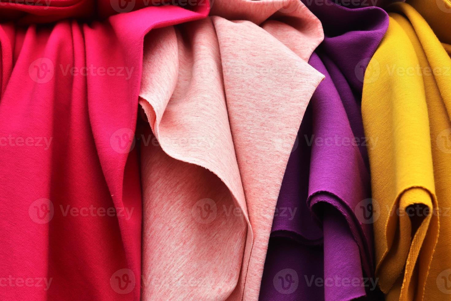 Detailed close up view on samples of cloth and fabrics in different colors found at a fabrics market photo