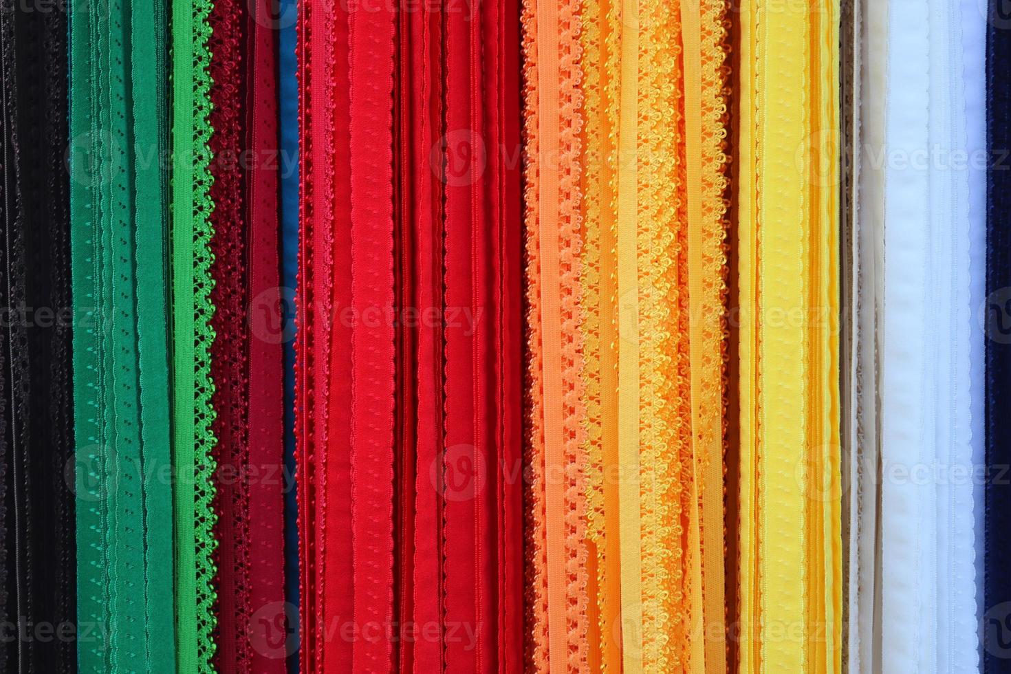 Detailed close up view on samples of cloth and fabrics in different colors found at a fabrics market photo