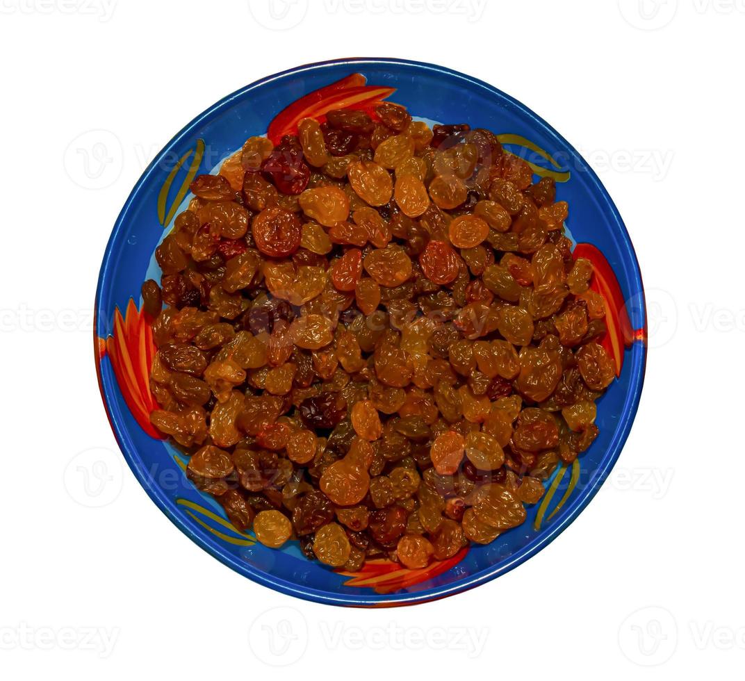 Raisins in a glass blue bowl. Isolated macro photo closeup from above
