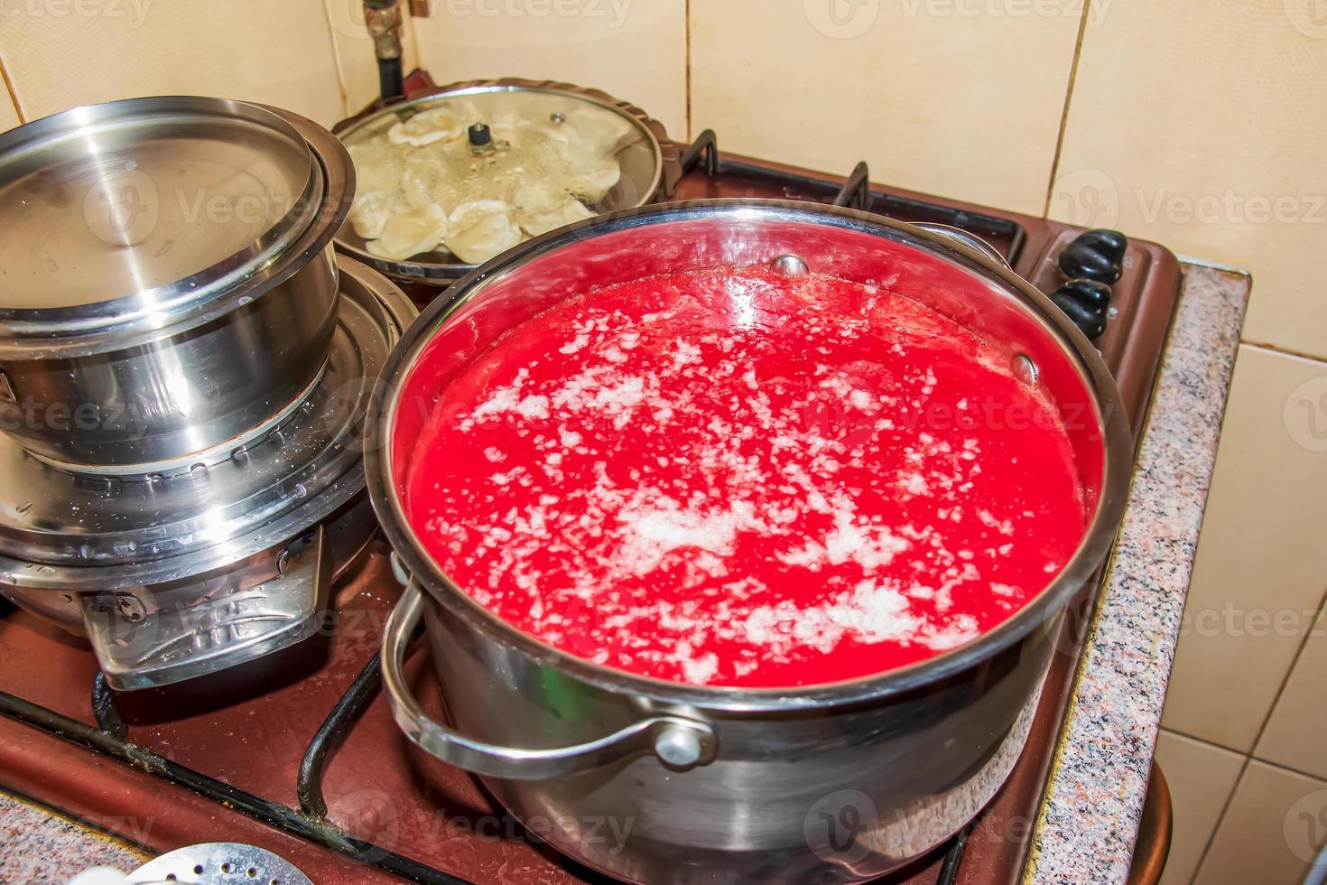 A woman prepares fresh healthy juice from tomatoes. Freshly made tomato juice is boiled in a saucepan and preserved for long-term storage. Diet concept for a healthy lifestyle. photo