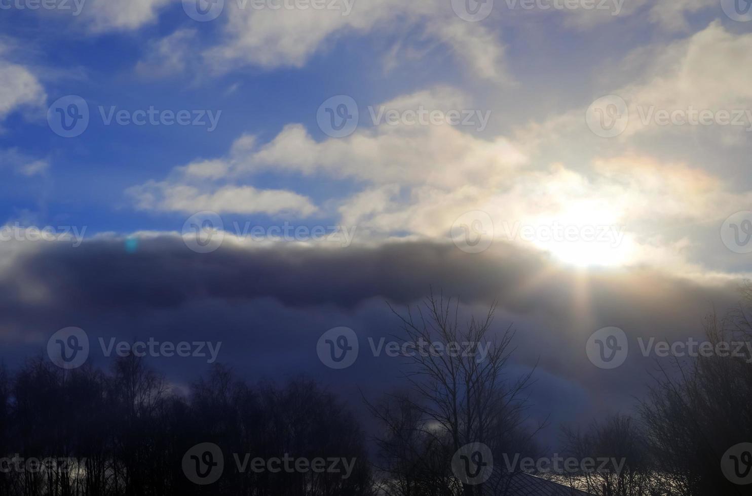 Beautiful view at sunbeams with some lens flares and clouds in a blue sky photo