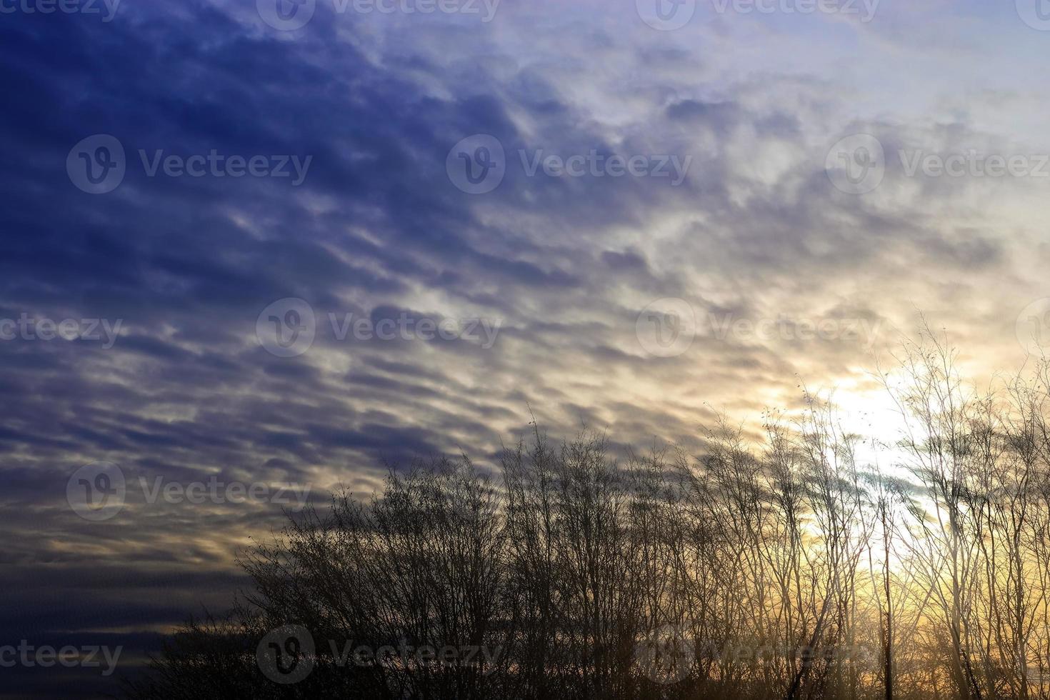 Beautiful view at sunbeams with some lens flares and clouds in a blue sky photo