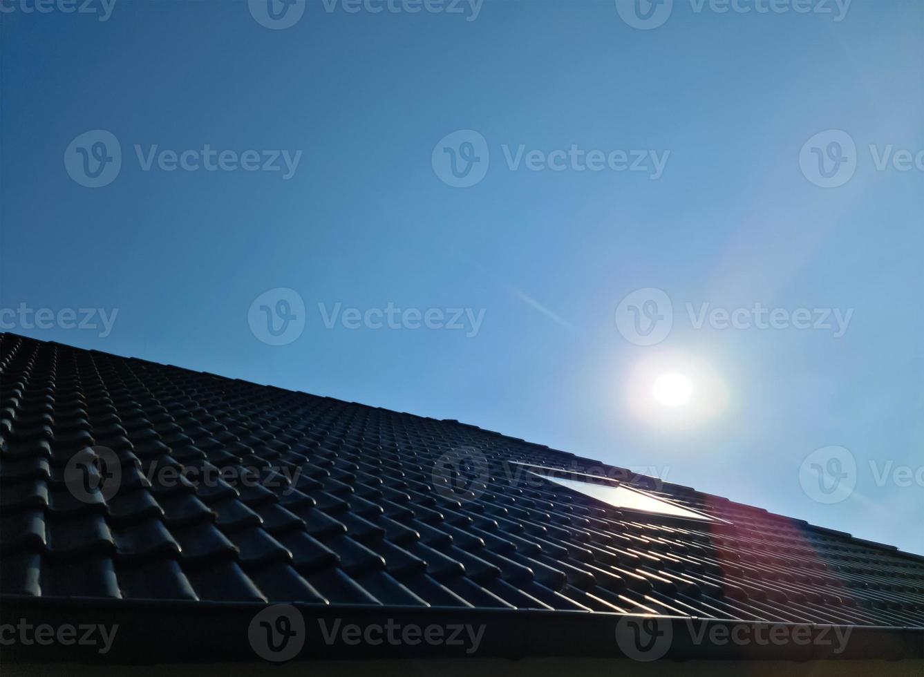 Open roof window in velux style with black roof tiles. photo