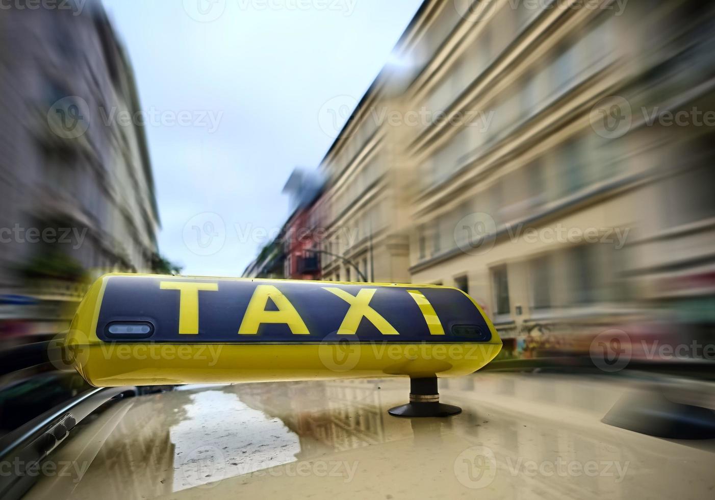A taxi sign on a car with a lot of motion blur on the city background due to high speed. photo