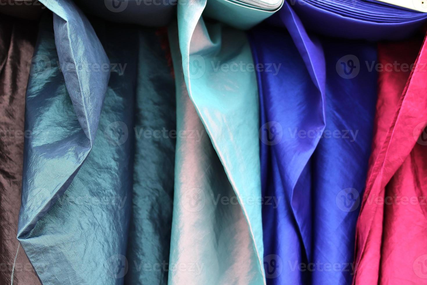 Detailed close up view on samples of cloth and fabrics in different colors found at a fabrics market photo