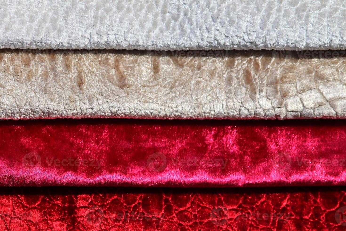 Detailed close up view on samples of cloth and fabrics in different colors found at a fabrics market photo