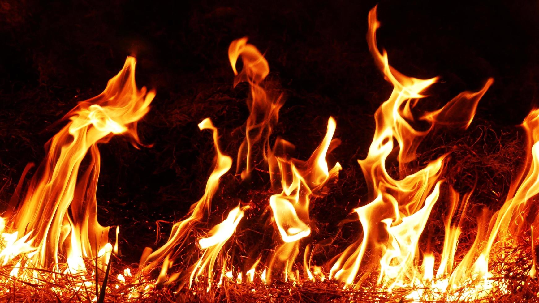 Haystack fires at night in arid areas The ash erupted and the wind was very dangerous. ashes red as hell. photo