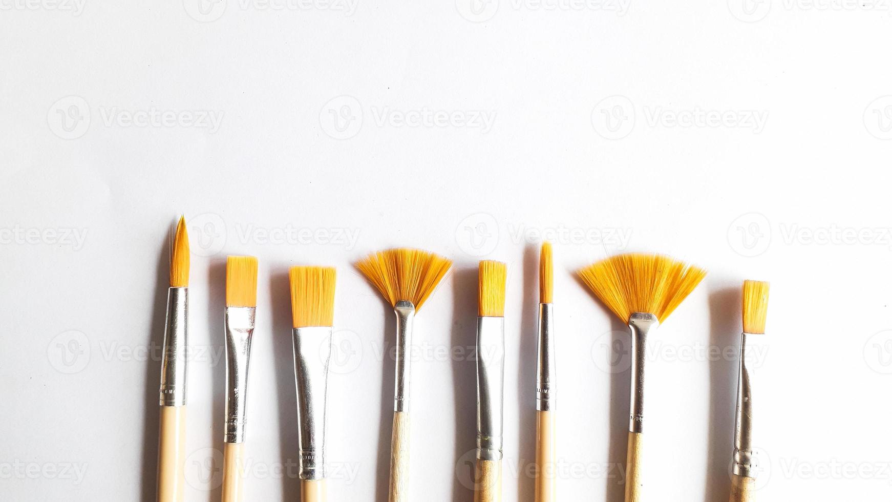 Top view of a variety of artist brushes on a white background with room for text. Creative postcard photo